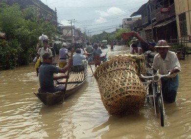 A Myanmar trishaw man wades through a flooded road near Yangon