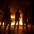 A Kashmiri protester is silhouetted during a late night protest. Indian forces battled Kashmiri protesters in the streets of the disputed territory Monday in demonstrations fueled in part by a report of a Qu'ran being desecrated in the US. (AP Photo/Altaf Qadri)