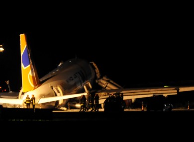 Italian firefighters stand near the Wind Jet Airbus 300 which landed off the tarmac at Palermo's Falcone e Borsellino Airport