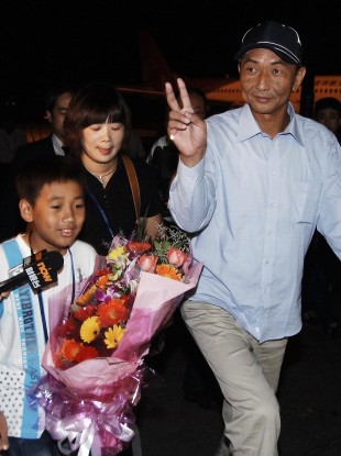 Zhan Qixiong, the Chinese trawler captain released from detention in Japan, is accompanied by his wife and son after arriving at the airport in Fuzhou