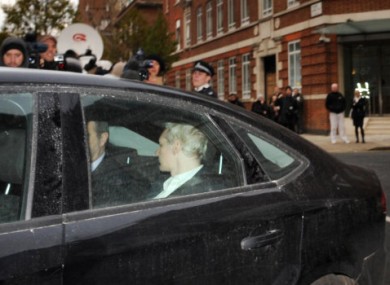 Julian Assange is driven into Westminster Magistrates Court in London yesterday.