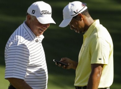 Mark O'Meara checks out something on Tiger's phone during a practice round at last year's Masters - don't ask!