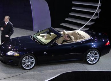 Lewis Booth, executive vice president of the Ford's Premier Auto Group of Europe stands next to a Jaguar XK convertible