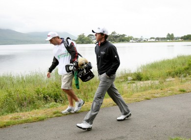 orthern Ireland's Rory McIlroy with caddy JP Fitzgerald make their way to third green yesterday.
