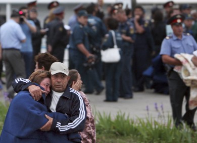 A relative, foreground right, and a survivor embrace each other upon the arrival of the Arabella riverboat with dozens of survivors of a shipwreck in Kazan on the Volga River, in central Russia