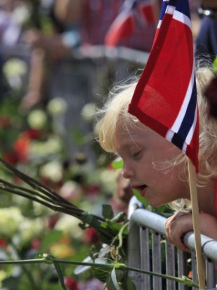 People gather around thousands of flowers and tributes laid outside the Oslo Cathedral in Oslo, in memory of the victims of July 22 bomb attack and shooting rampage.