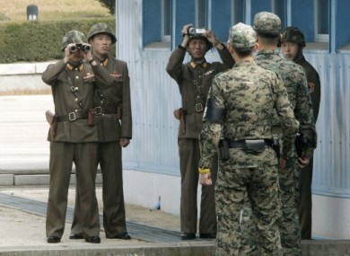 North Korean Army soldiers, background, look at the southern side as South Korean Army soldiers stand guard at the border village of Panmunjom in October 2010.