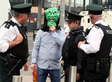 A man conceals his identity with a Halloween mask as he arrives at Belfast crown court for the so-called 'supergrass' trial today.