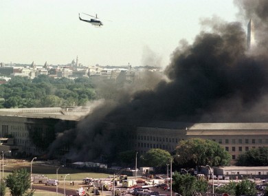A helicopter flies over the burning Pentagon on 11 September 2001.