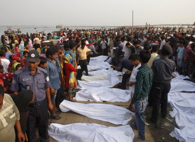 A crowd gathers around the dead bodies of victims of a ferry that capsized in the Meghna River