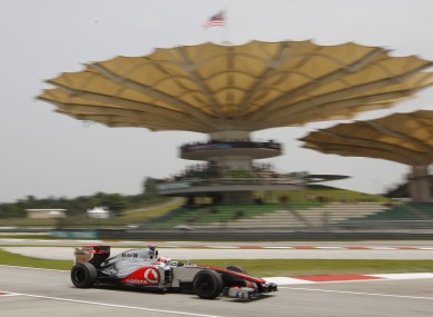 McLaren Formula One driver Jenson Button of Britain steers his car into the pits.