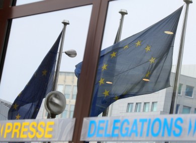 EU flags wave as they are mirrored at the European Council building in Brussels