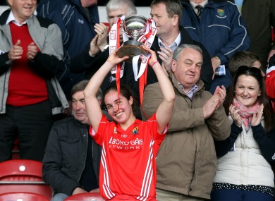Cork captain Julia White lifts the Division 1 trophy.