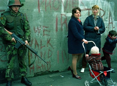 Women and children stand beside an armed British soldier in Belfast, days after Bloody Sunday in 1972