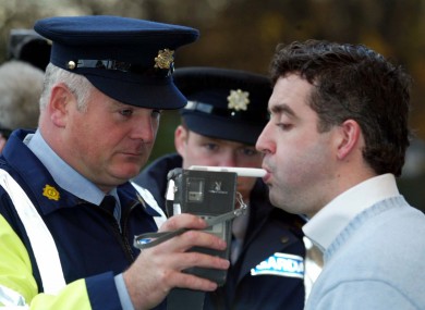 A Garda breathalises an actor during a mock driving test