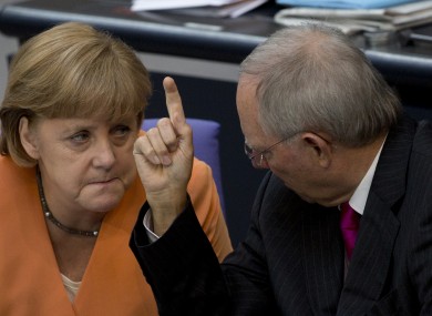 German Finance Minister Wolfgang Schaeuble, right, gestures as he speaks to German Chancellor Angela Merkel.