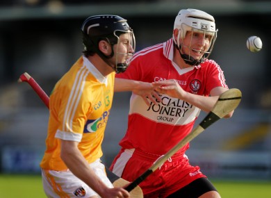 Derry's Ciaran McIntyre in action with Antrim's Stephen Smith.