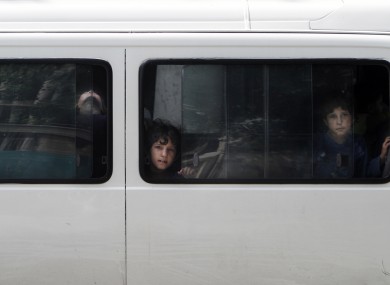 Afghan children look out of a bus window in Kabul today.