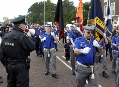 Police calling on a loyalist band to stop as it passed St Patrick's church in Belfast yesterday.