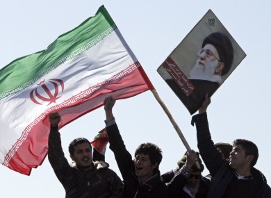 File photo of Iranian youths with the country's flag and poster depicting supreme leader Ayatollah Ali Khamenei