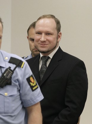 Anders Behring Breivik smiles as he arrives in the courtroom to hear its verdict earlier today.