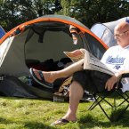 Dave Johnston from Brighton reads the paper and tries to relax after having his tent robbed last night Photo: Laura Hutton/Photocall Ireland