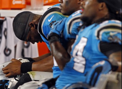 Carolina Panthers quarterback Cam Newton lowers his head while sitting on the bench against the New York Giants.