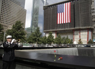 New York City Fire Department captain Tom Engel plays taps during the observance at the World Trade Center Memorial.