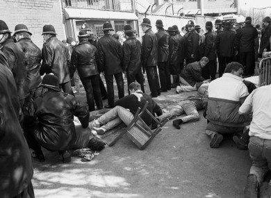 A line of Policeman shield some injured fans as they receive treatment at Hillsborough in 1989.