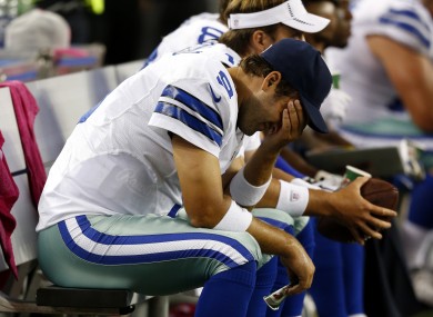 Cowboys quarterback Tony Romo holds his head after throwing the fourth of five interceptions against the Bears.