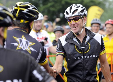 Lance Armstrong greets fellow riders prior to the start of his Livestrong Challenge 10K ride for cancer in 2010.