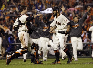 Giants relief pitcher Sergio Romo and catcher Buster Posey react after the final out.