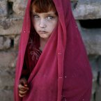 Afghan refugee girl, laiba Hazrat, 5, stands next to her home while she and other children, not pictured, celebrate the Muslim holiday of Eid al-Adha, or 