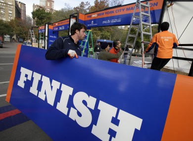 Workers assemble the finish line for the New York City Marathon at Central Park.