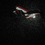 Snow is illuminated by a street light as an American flag blows in the wind during a winter storm in Paducah, Ky. An enormous storm system that brought snow and sleet to the nation's midsection -- and tornadoes to the Deep South -- is now moving its way toward the Northeast. (AP Photo/Stephen Lance Dennee)