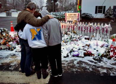 Members of the Rutter family of Sandy Hook, Conn., embrace early Christmas morning as they stand near memorials by the Sandy Hook firehouse in Newtown