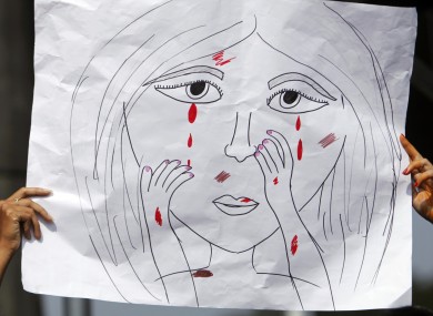 An Indian student holds a cartoon during a march to mourn the death of a gang rape victim in Hyderabad, India.