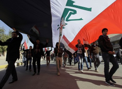 Protesters chant pro-Iraqi Prime Minister Nouri al-Maliki slogans as they carry a huge Iraqi flag during a demonstration to show support for Al-Maliki's government, in Baghdad, last Saturday.