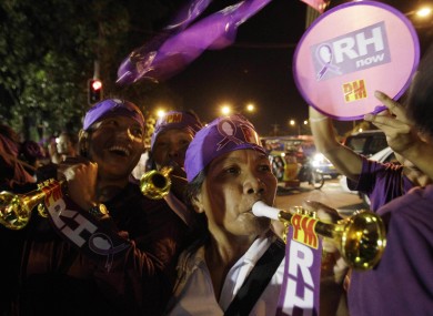 Filipino women celebrate after hearing news that Philippine legislators passed a landmark law