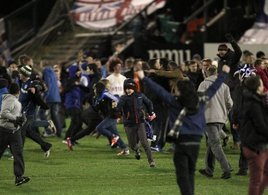Oldham Athletic fans invade the pitch after the final whistle as they celebrate victory over Liverpool.