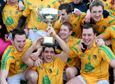 The Leitrim team celebrate as captain Emlyn Mulligan holds the trophy.