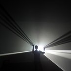 A Hayward Gallery employee poses for photographers inside artist Anthony McCall's installation entitled 'You and I, Horizontal' at the gallery in London. The exhibition 'Light Show' featuring 25 illuminated installations and sculptures by artists from the 1960's to the present, will run from Jan. 30, 2013 to April 28, 2013. (AP Photo/Lefteris Pitarakis)