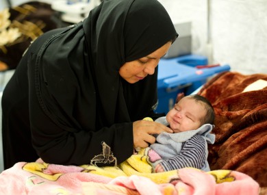 A mother cares for her child at a Red Cross Red Crescent field hospital in Mafraq, Jordan