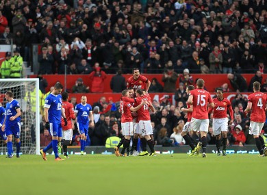 Manchester United's Ryan Giggs celebrates scoring his team's first goal of the game with teammates as Everton players look on dejected.
