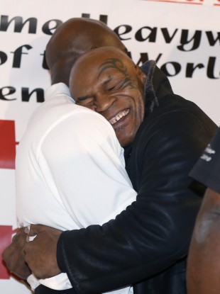 Former heavyweight champion Mike Tyson hugs fellow former champion Evander Holyfield during a promotional event for Holyfield's Real Deal barbecue sauce at a Chicago grocery store yesterday.