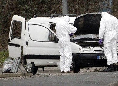 Police forensic officers examine a car in which four mortar rounds were found in Derry